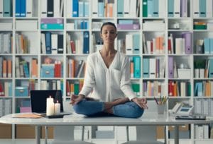 Woman practicing meditation on a desk